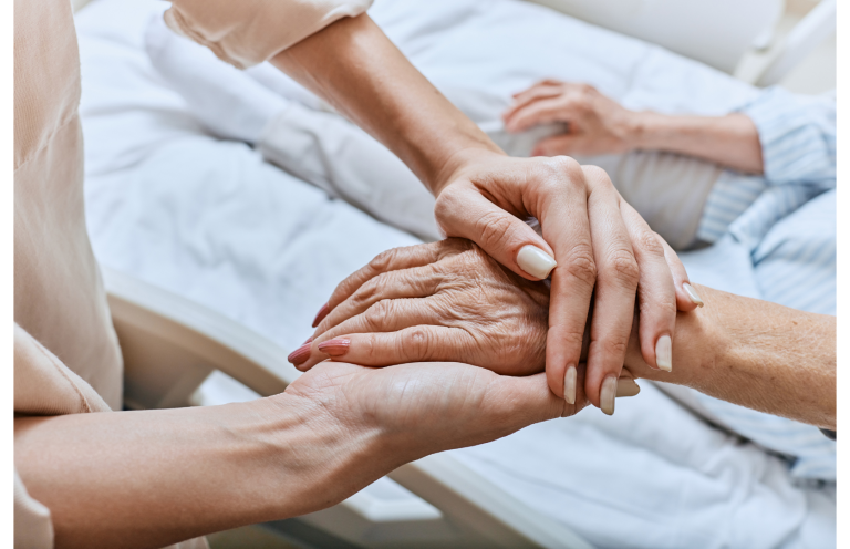 A healthcare worker cleans a table in a hospital setting while patients are treated nearby.
