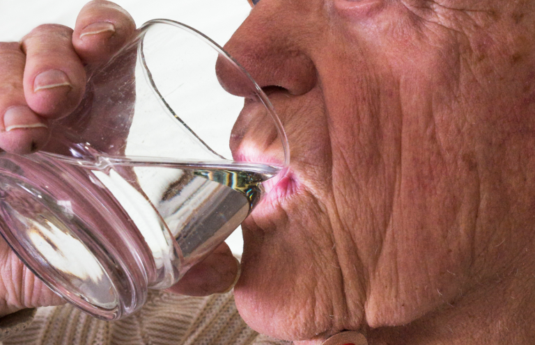 Dysphagia Awareness An elderly person drinking water from a glass.