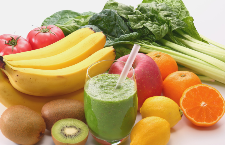 A selection of fresh fruits and vegetables with a green smoothie.