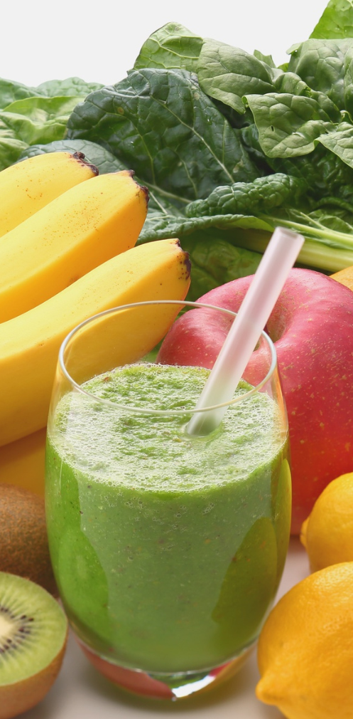 Nutrition and Hydration A glass of green smoothie surrounded by fresh fruits and leafy greens.