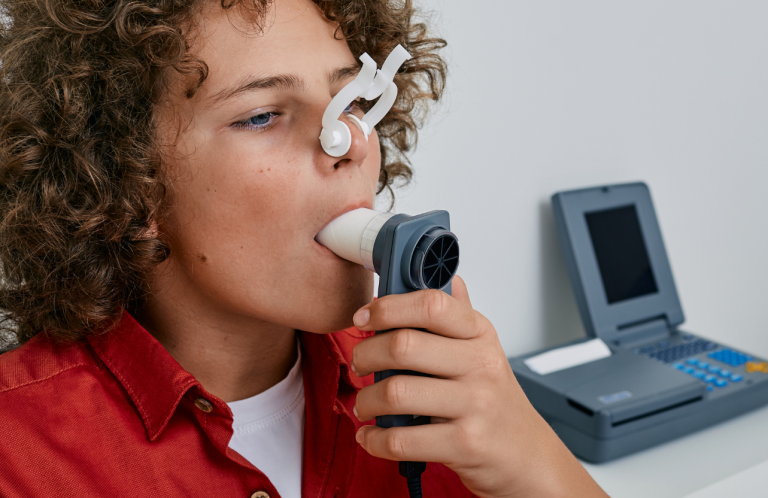 A boy using a spirometer during a medical examination.