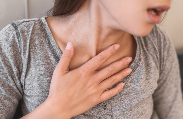 A person with a hand on their chest, showing signs of respiratory distress.