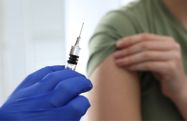 A person receiving foot care, with hands pointing to the ankle area.