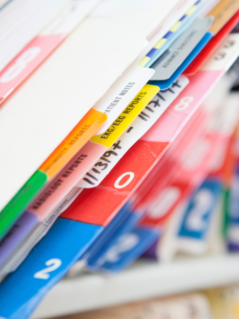 Colourful file folders with tabs, arranged in a stack.