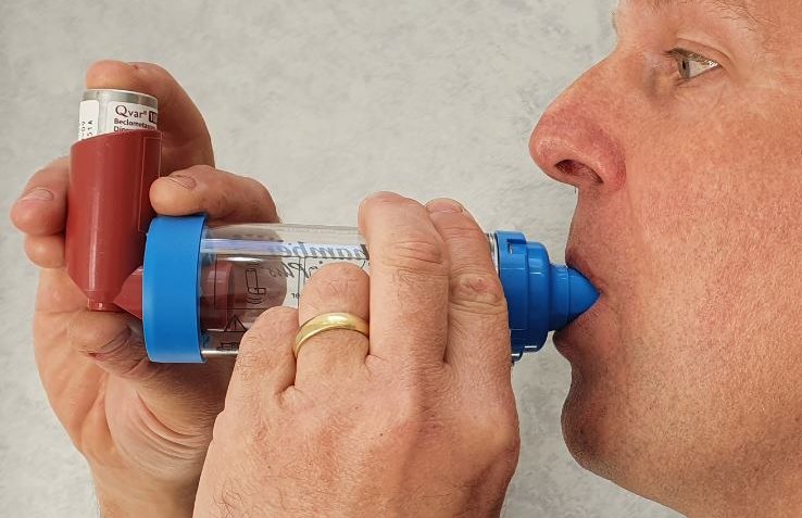 Asthma and COPD Foundation Training A person using an inhaler for asthma relief.