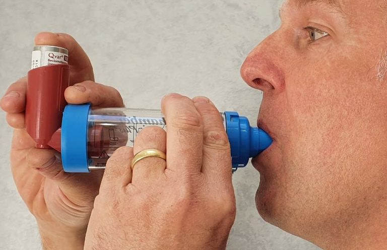 Asthma Update Training A man using an inhaler to manage asthma symptoms.