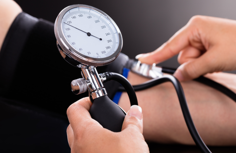 Blood Pressure Measurement A person measuring blood pressure with a sphygmomanometer on a patient's arm.