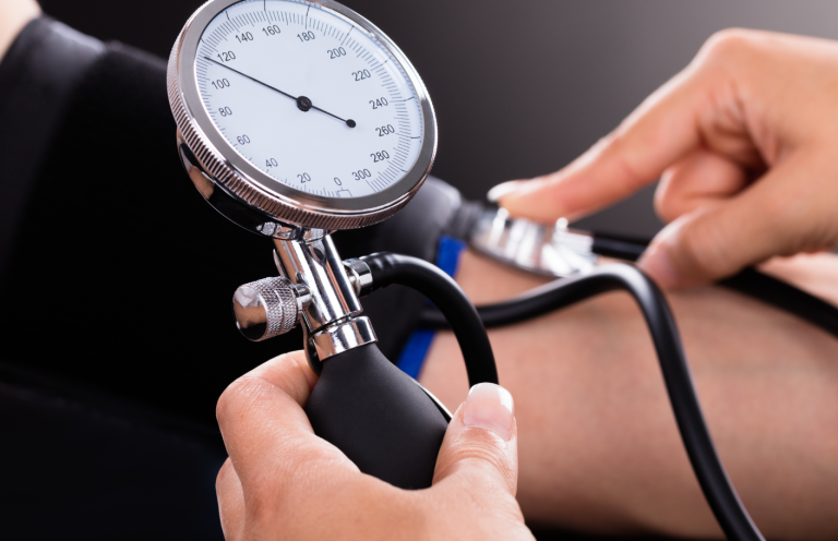 Blood Pressure Measurement Training A person measuring blood pressure using a sphygmomanometer on a patient's arm.