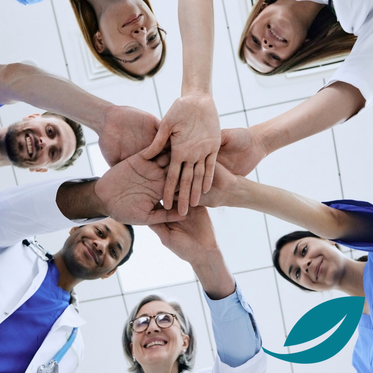 Week 6 - assessment and completion A diverse group of healthcare professionals joining hands together.