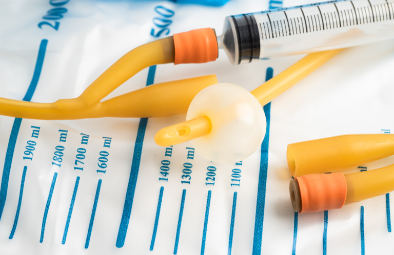 Catheterisation Training for Registered Practitioners Medical tubing and a syringe on a marked medical sheet.