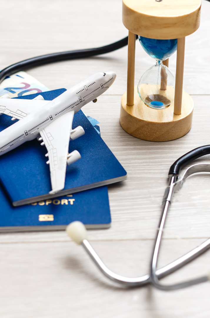 A model airplane on blue surface alongside travel documents and a stethoscope.