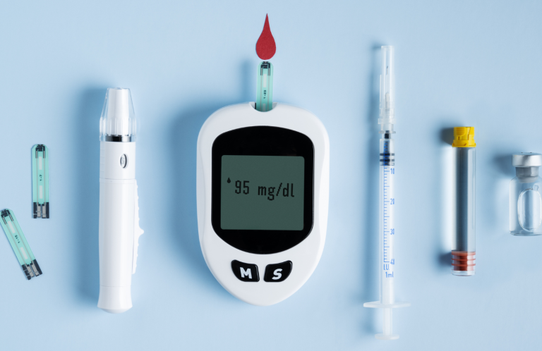 Diabetes and Insulin Administration Blood glucose meter with test strips, lancet device, and syringes on a blue background.