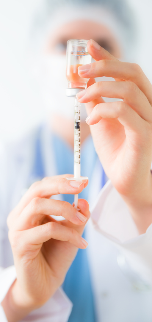 A healthcare professional holding a syringe ready for use.