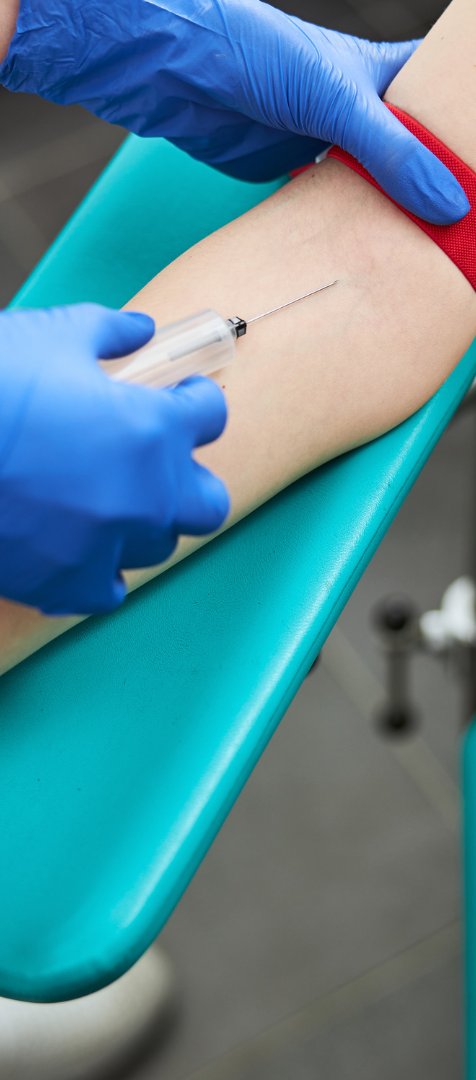 A healthcare professional preparing to extract blood from a patient's arm.